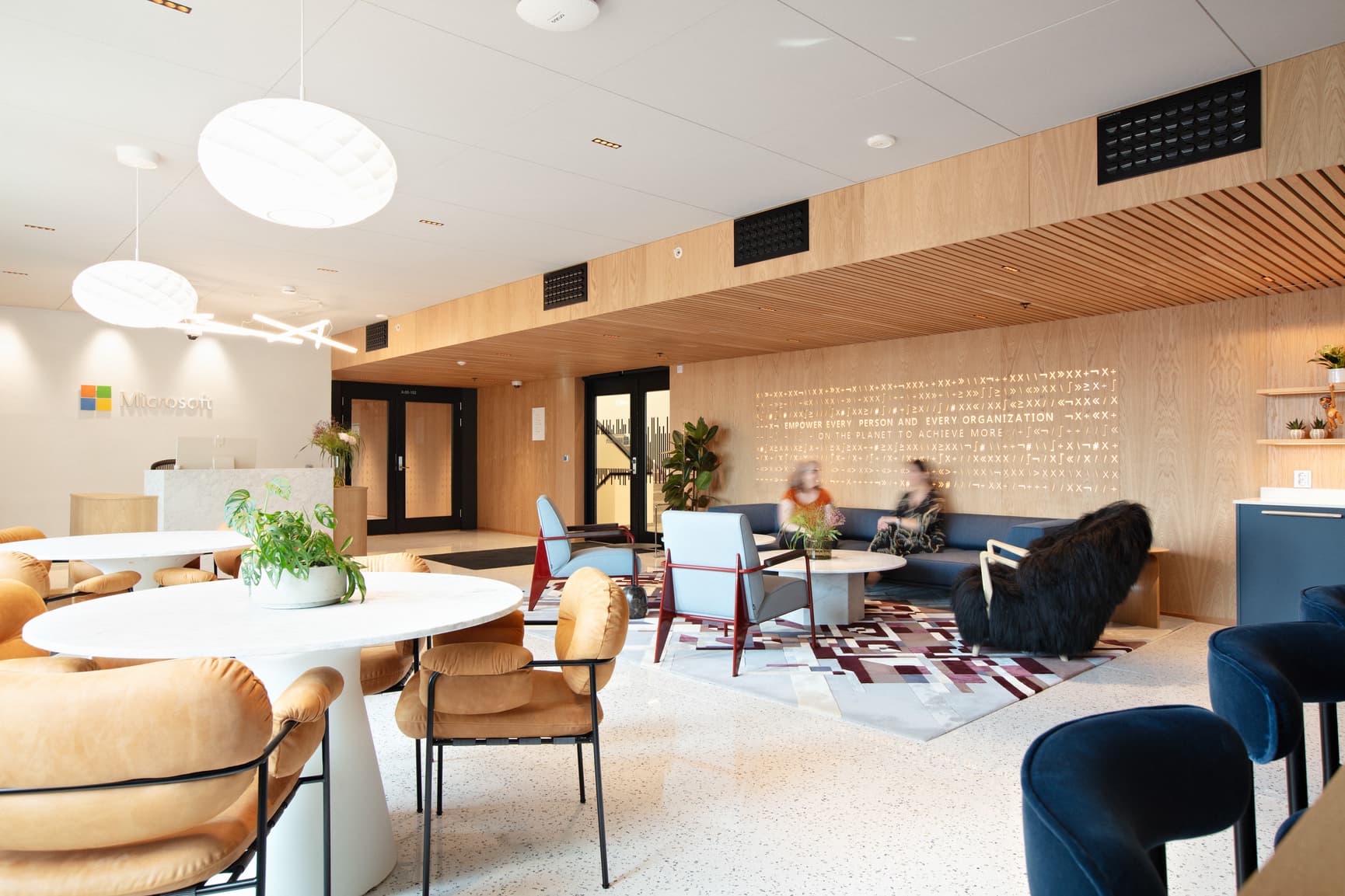 Interiør i lokalene til Microsoft i Trondheim, med terrazzogulv, treverk og varme farger på møbler og øvrig interiør